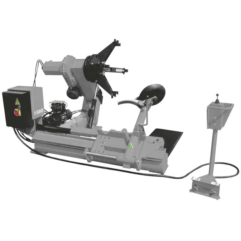 Seitenansicht einer schweren industriellen Reifenmontiermaschine für Nutzfahrzeuge mit hydraulischem Montagearm, rotierendem Spannkopf, Abdrückrolle, integriertem Hydraulikaggregat und separatem Bedienpult, robuste Bauweise in Grau und Schwarz vor weißem Hintergrund.