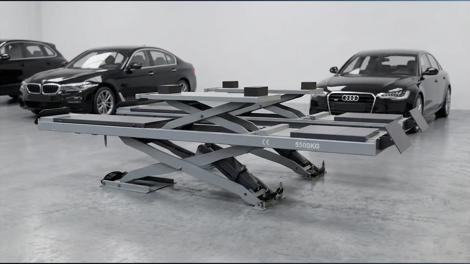 Niedrige Scherenhebebühne für Fahrzeuge mit ausgefahrenen Plattformen in einer Werkhalle; im Hintergrund stehen mehrere Limousinen.